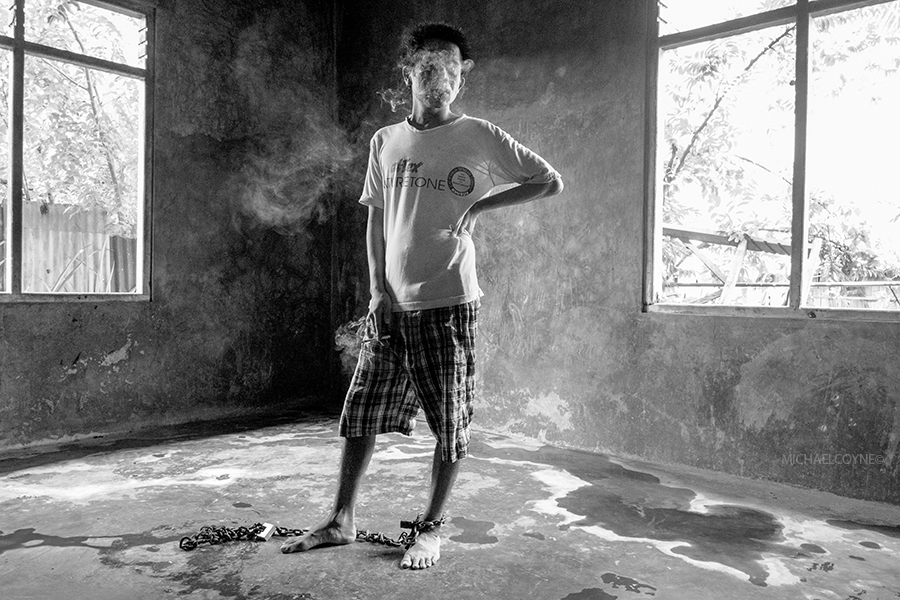 Young man with a mental illness is chained to the floor of his room as a safety precaution. Flores, Indonesia